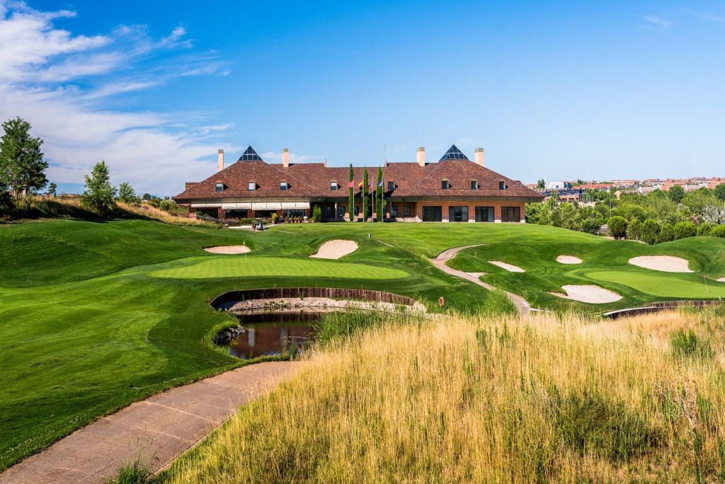Clubhouse and greens at Centro Nacional de Golf with the Madrid skyline behind, a course you can play on a golf trip to Madrid without a car