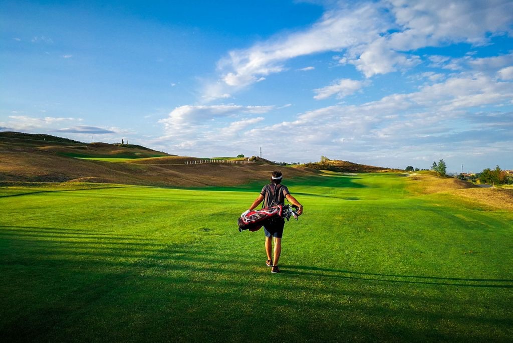 A lone golfer walking up a fairway at Centro Nacional de Golf in Madrid carrying his own bag