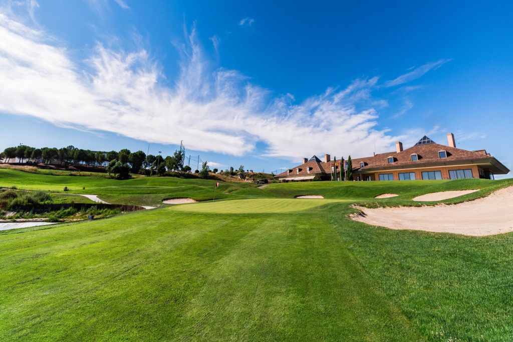 Approach to a green at Centro Nacional de Golf in Madrid with the clubhouse behind it